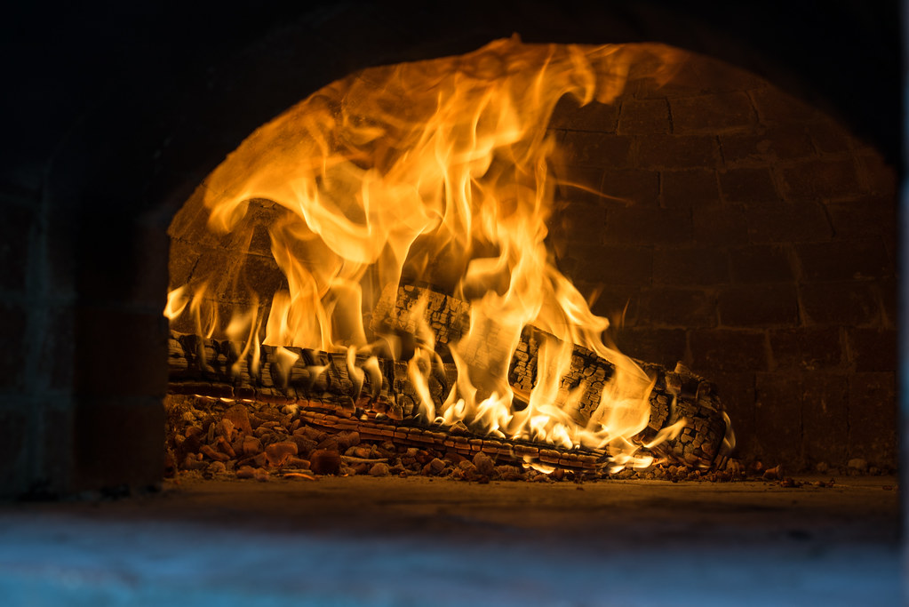 Professional pizza cooking in wood-fired oven